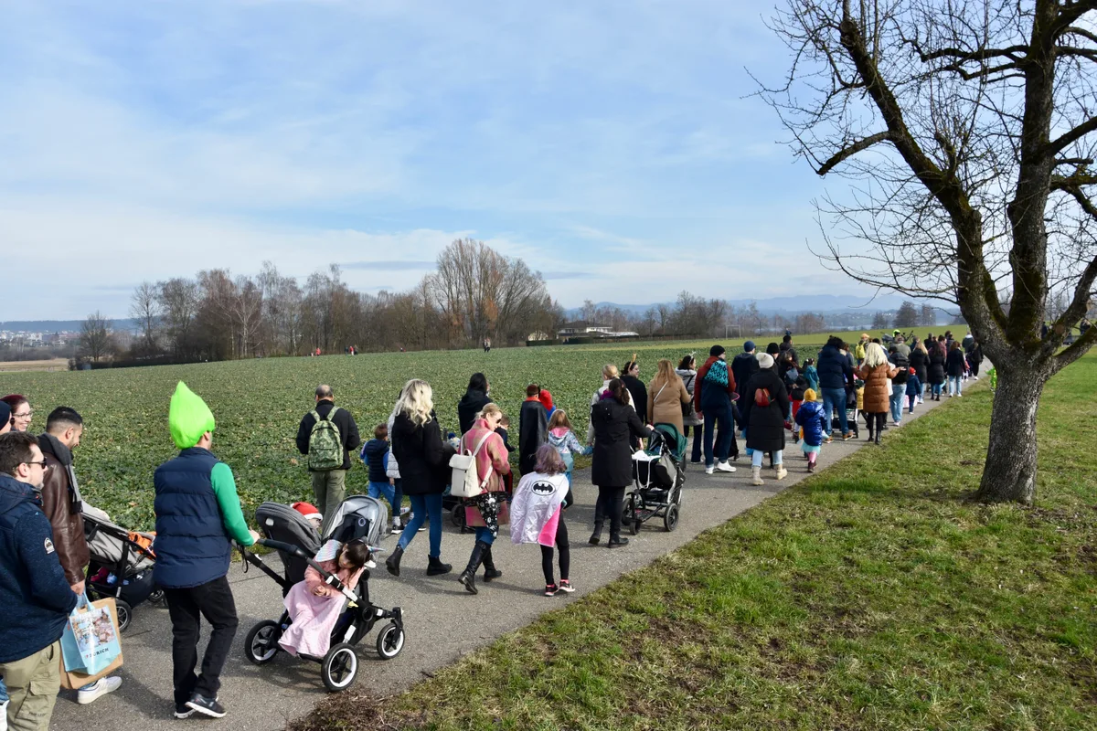 Der Umzug ging in Richtung des Zwicky-Areals. Menschen gehen einen Feldweg entlang.